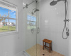 Walk in shower fits multiple people and has two rain shower heads along with handheld sprayers