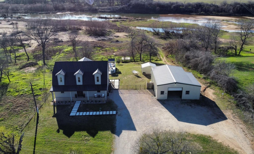 Overview of the property which includes home, two shops, pool with deck, and a large fenced in area for horses
