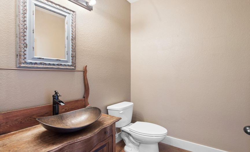 The half bathroom features a custom cabinet and vessel sink.  
