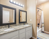 The hall bathroom features double vanities and a large linen cabinet.  