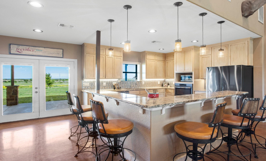 The kitchen features granite counter tops, stainless steel appliances, and bar top seating.  