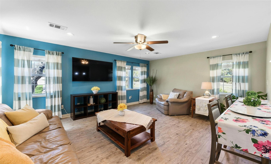 Step into the inviting guest house living room, a cozy space adorned with a ceiling fan and recessed lighting, perfect for relaxation and unwinding.