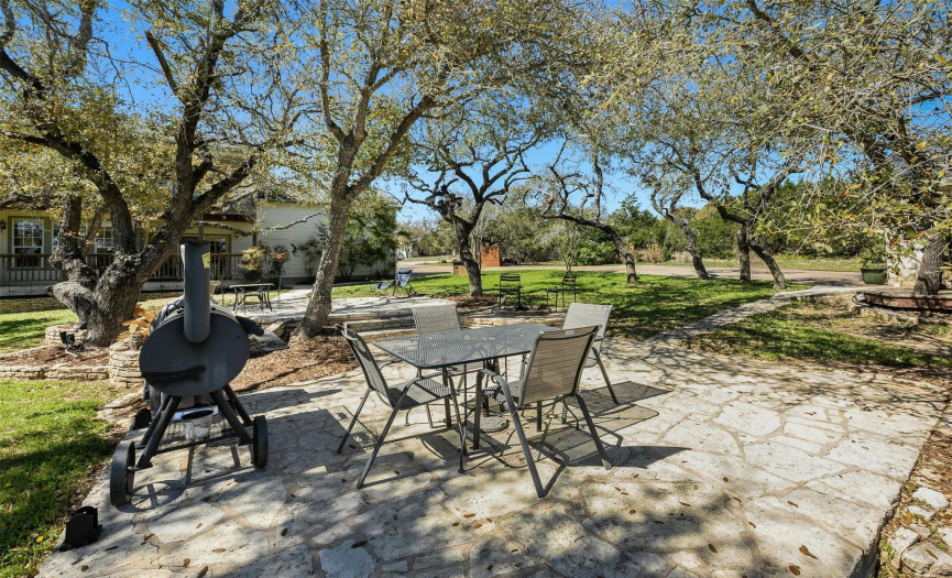 Mature trees dot the backyard, providing shade and a picturesque backdrop for outdoor gatherings.
