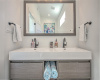 Primary guest bath has floating double vanities and a simple, modern flow
