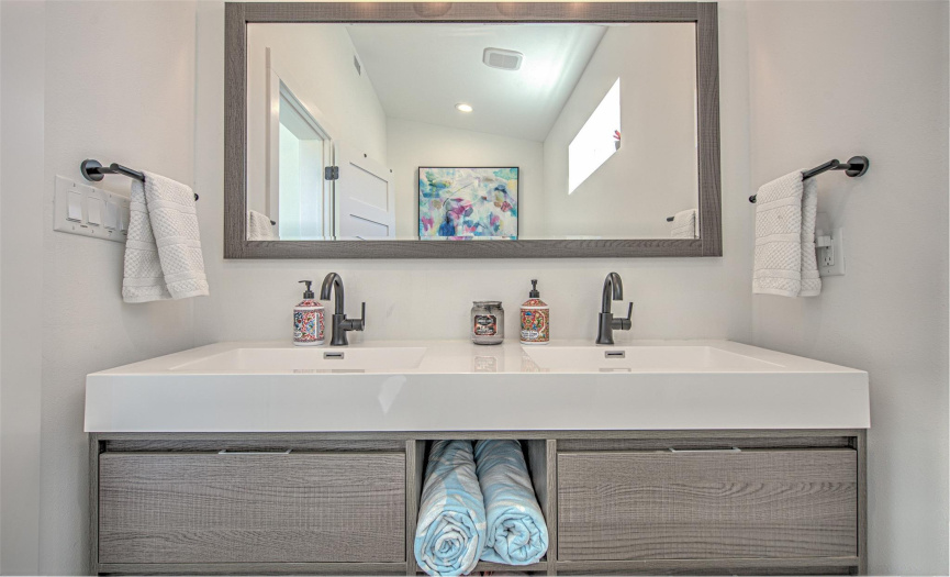 Primary guest bath has floating double vanities and a simple, modern flow