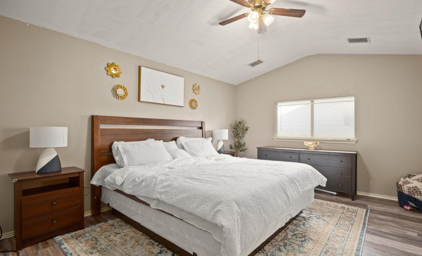 The primary bedroom offers great privacy and features a vaulted ceiling and a spacious walk-in closet.