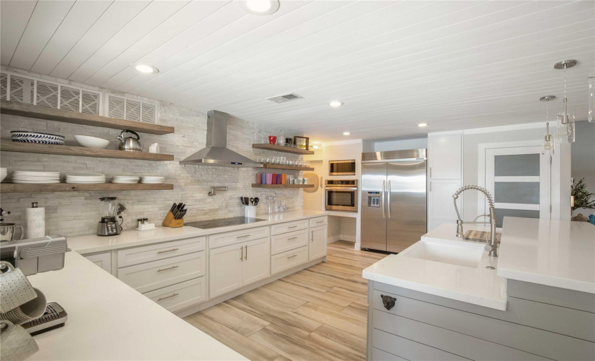 Gather with loved ones in the open-concept kitchen, featuring a large center island and breakfast bar, perfect for casual dining or entertaining guests.