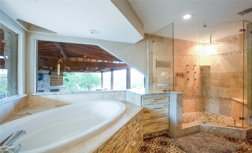 Experience spa-like luxury in the primary bathroom's oversized frameless walk-in shower, where sleek finishes and modern design elements create a rejuvenating retreat.