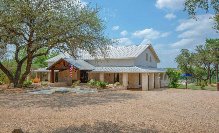 Experience the allure of Hill Country living from the charming covered front porch, offering a warm welcome and inviting space to enjoy the serene surroundings.