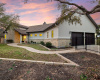 A welcoming home graced by twilight skies, with a beautifully lit entrance and secure, elegant iron gates for privacy.