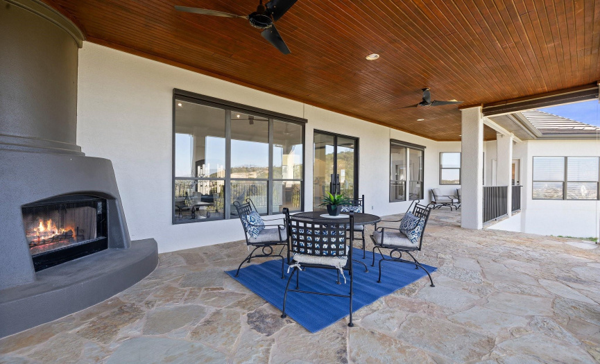 Spacious outdoor patio with a cozy fireplace and scenic views.