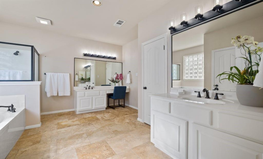 This primary bathroom is crispy clean and has tons of storage plus a large walk in closet. 