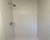 Primary bathroom has new subway tile in shower stall. Drain pan and valves were replaced too. 
