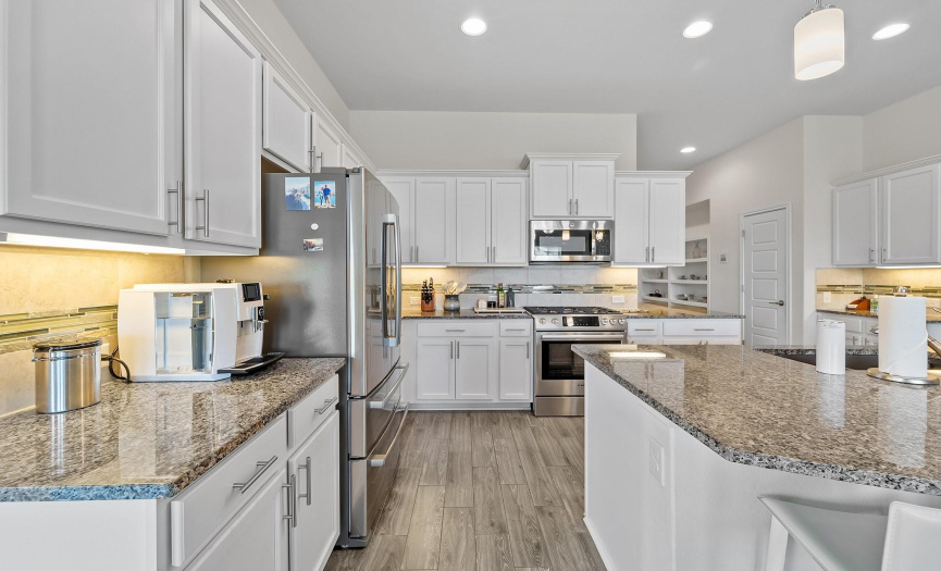 The layout of this kitchen is both functional and inviting, with ample counter space for meal preparation and stylish cabinetry providing plenty of storage for all your culinary needs.