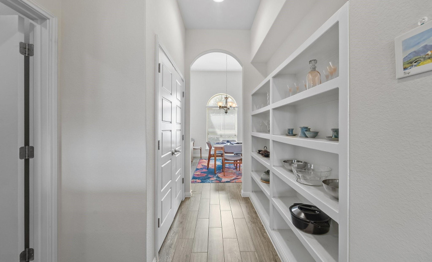 The kitchen flows effortlessly into this butler's pantry, strategically positioned for convenient storage needs.  This practical space sits just opposite the expansive utility room.