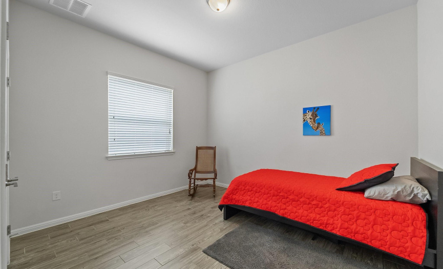One of two secondary bedrooms boasting a spacious and inviting  atmosphere.
