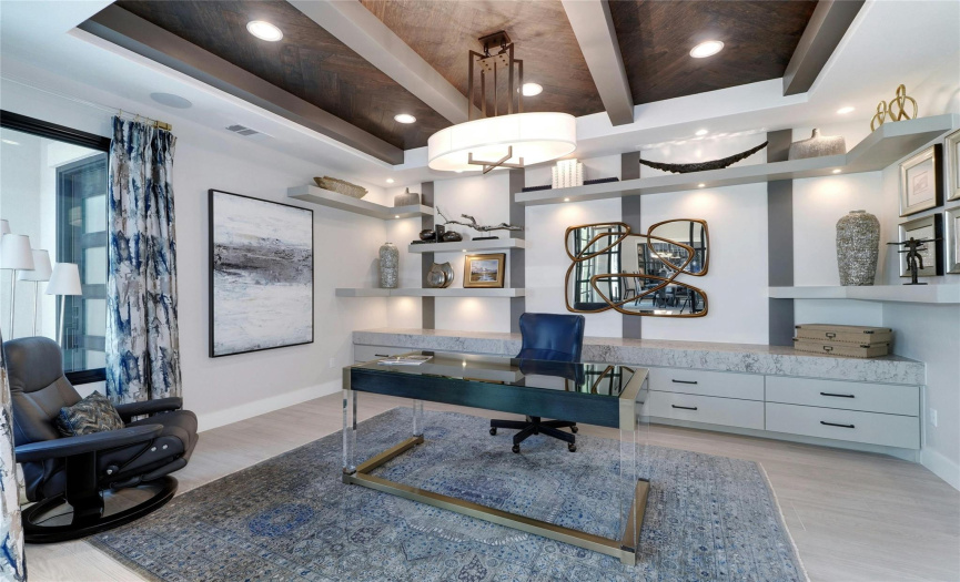 Custom ceiling design and recessed light creates a warm office/studio atmosphere. Built-in in cabinets for files, undershelf lighting and glass barn doors which open onto the front entry make this an ideal work space.