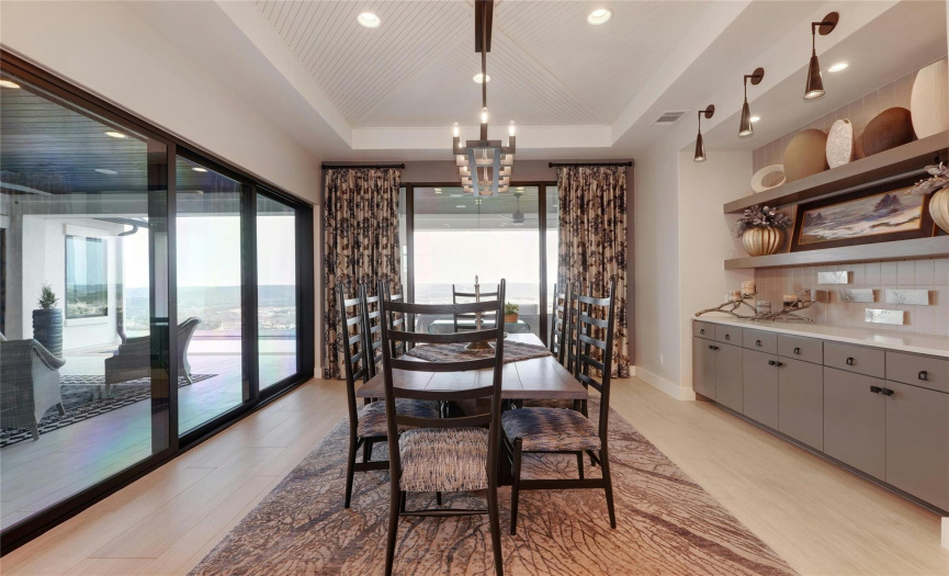 Breakfast area which is open to the kitchen has specialty lighting, custom tray ceiling, and many cabinets. Quartz counter top makes a perfect space for a breakfast buffet. It has its own 12' multi-slide glass door and of course that view that grabs your attention.