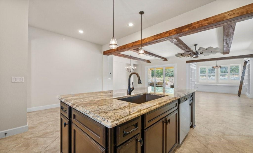 Huge island in well equipped kitchen is perfectly positioned to entertain and cook.