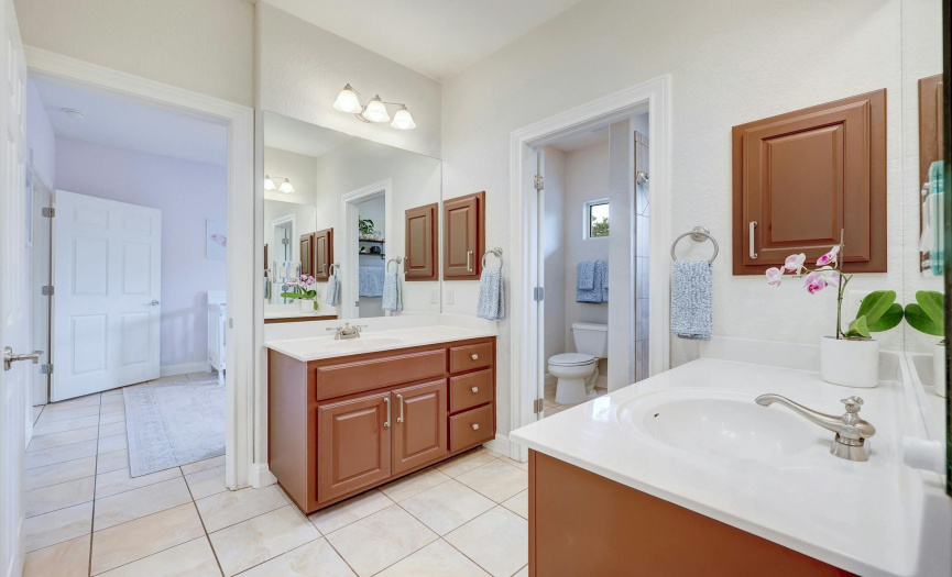 Shared bathroom with separate vanities and large linen closet