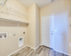laundry room has ample storage with built in shelving on other wall 