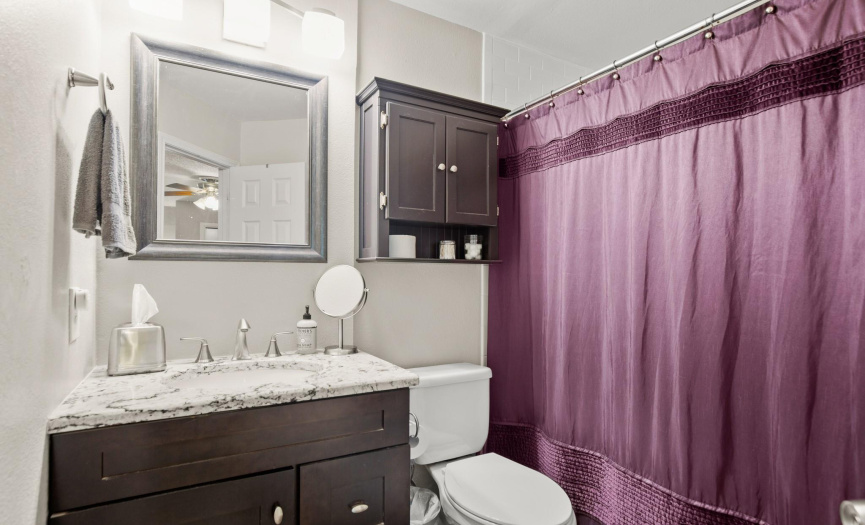 The private ensuite bathroom offers a lovely vanity with granite countertop and a shower/tub combo. 