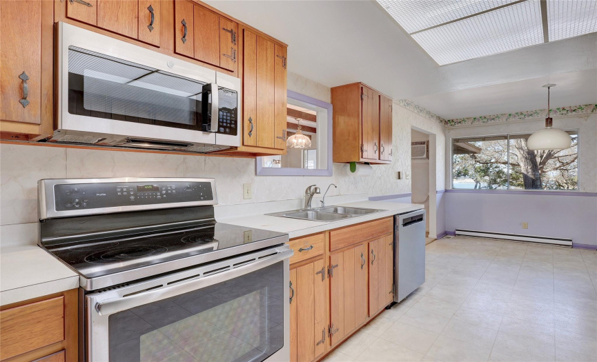 Kitchen is equipped with stainless appliances and lake views from the breakfast area.