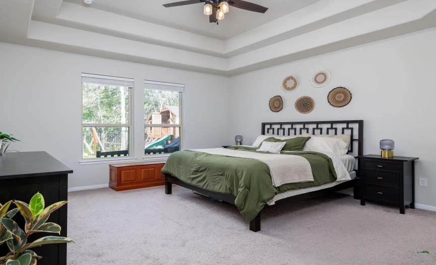 Spacious primary bedroom with double tray ceilings