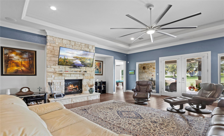 Open Living Room with Stone Fireplace and Oversized Ceiling Fan