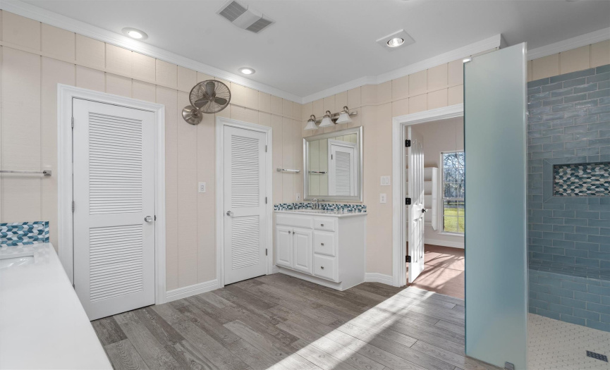 Luxuriate in this sophisticated bathroom, where contemporary fixtures meet classic comfort. The broad mirror reflects a spacious vanity, ensuring a refreshing and rejuvenating start to your day.