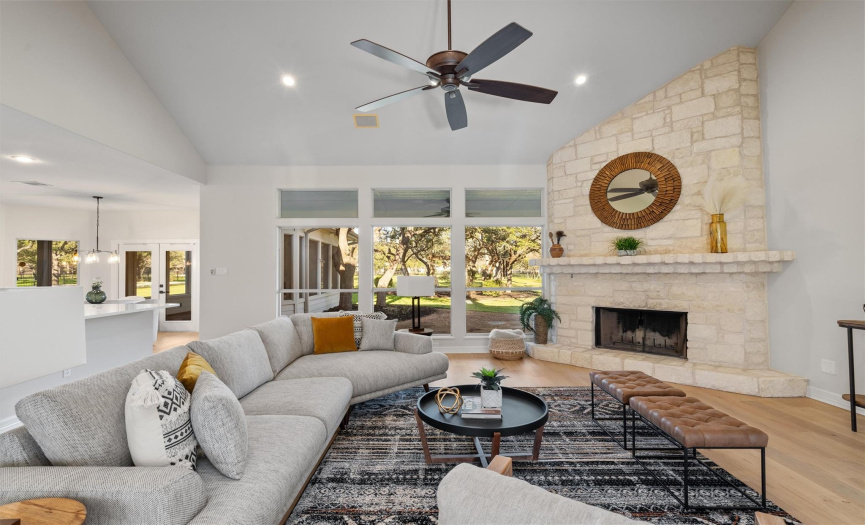 The heart of the home beats in this spacious living room, anchored by a stunning stone fireplace. Vaulted ceilings and large windows create an airy, expansive atmosphere, perfect for entertaining guests or unwinding with family amidst the tranquil views of your backyard oasis.