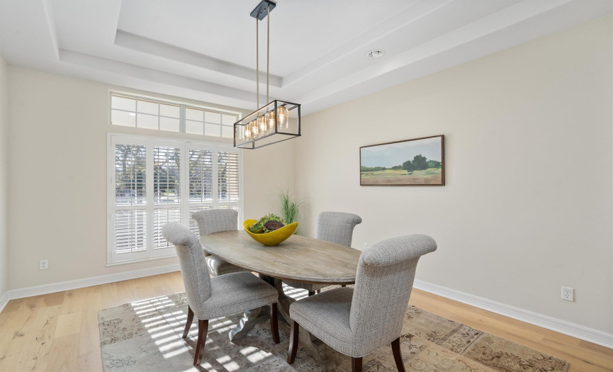 Gather around this naturally lit dining area where memories are waiting to be made. The expansive windows bring the outside in, while the contemporary lighting fixture above the round table casts a warm glow over your family feasts and friendly gatherings.