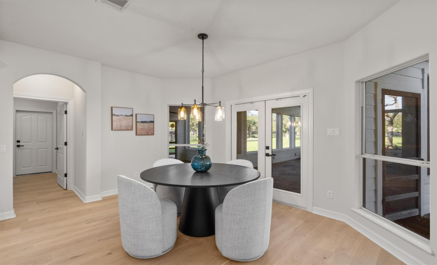 Start your mornings in this cozy breakfast nook, featuring an elegant table complemented by plush seating. Natural light floods in, offering a peaceful setting for your morning coffee while overlooking the serene outdoor scenery.