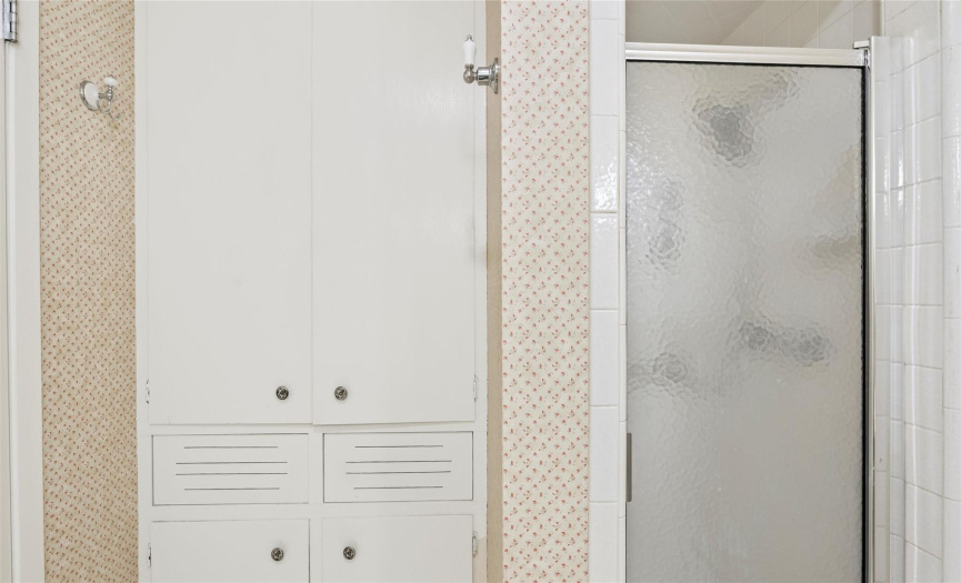 The primary ensuite also comes with a standing shower plus retro built-in linen storage. 