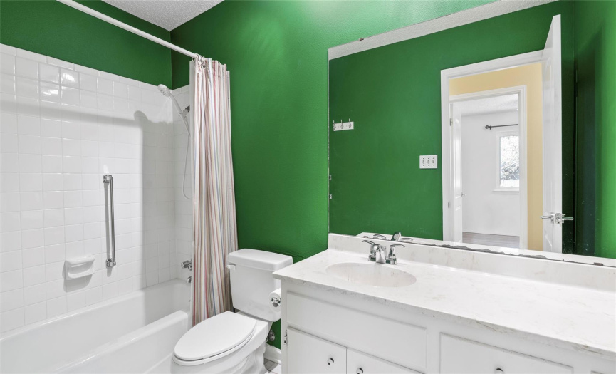 The full secondary bath provides a spacious single vanity and a shower/tub combo with tile backsplash. 