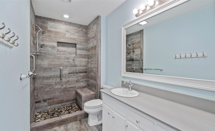 This beautifully updated ensuite bath features a spacious single vanity, gorgeous tile floors, and an amazing walk-in shower.