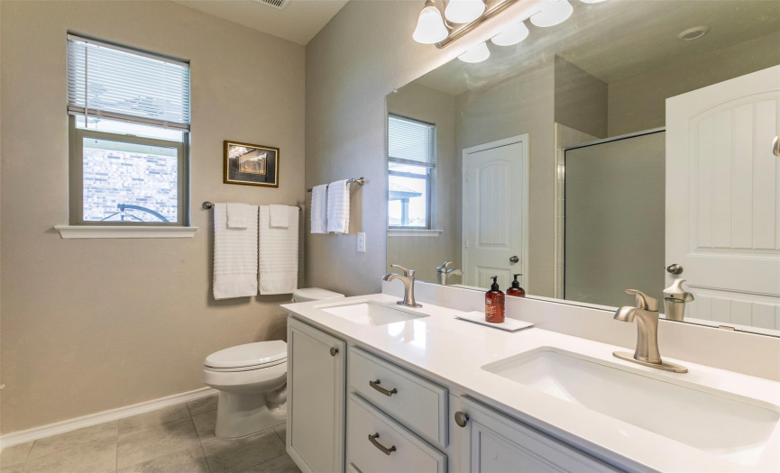 The lovely primary bath has double vanities with upgraded fixtures. 