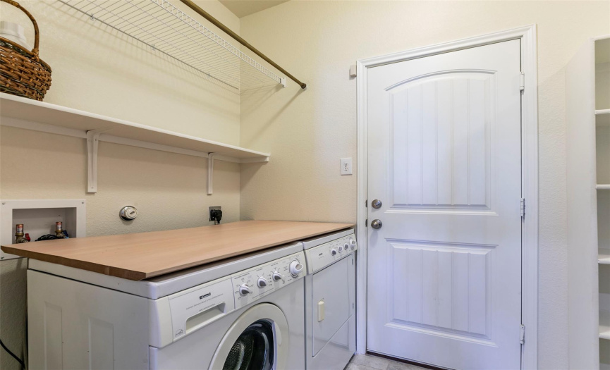 The laundry room just through the garage door makes for a perfect drop zone and has a convenient folding table, hanging rack, and shelves.  Washer and dryer included! 