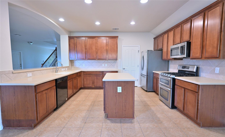 The kitchen is expansive, boasting a sizable center island and ample countertop space, perfect for cooking and meal preparation.