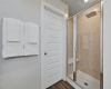 The bathroom also has access to the primary closet and a glass wall shower with bench.