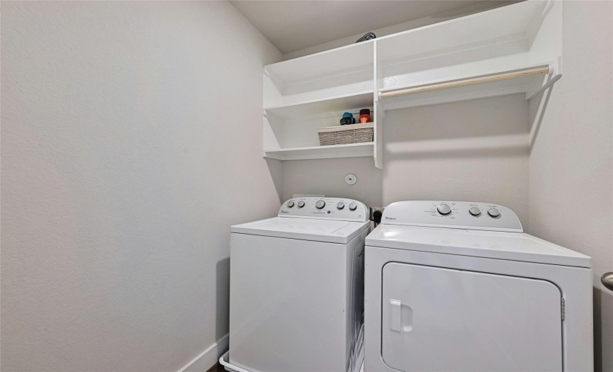 The utility room on the second floor has enough space for side-by-side units and built in shelving for storage.