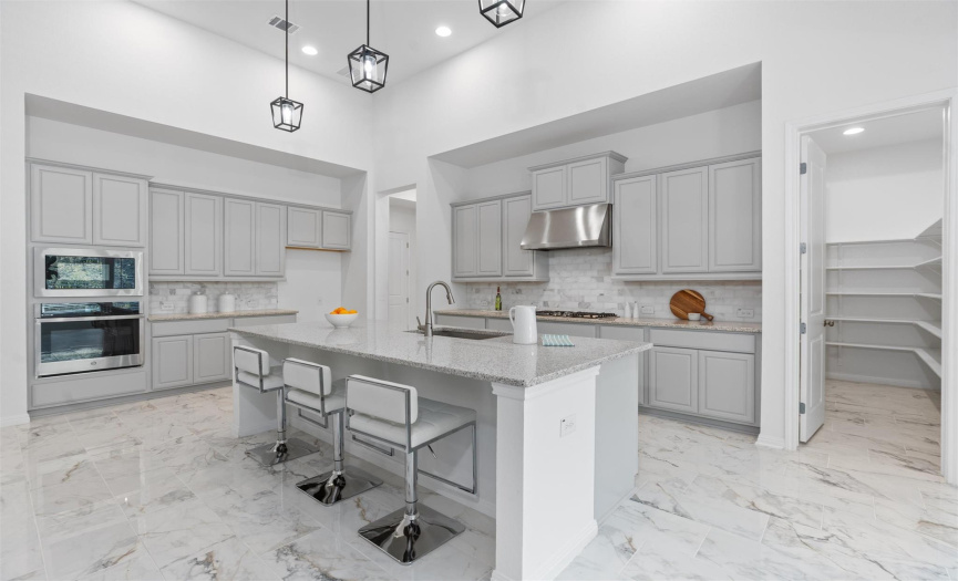 Stunning kitchen featuring granite countertops with high end cabinets and a kitchen island perfect for a quick bite to eat. 