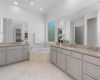 Primary bathroom features granite countertops with marble floors and walls. 