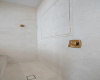 Primary walk in shower features 24 carat gold plated brass accent with marble herringbone.