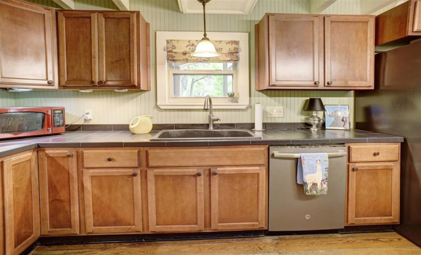 The butler's pantry, a near-full kitchen extension, boasts ample storage in custom cabinets, complete with a sink, microwave, dishwasher, and walk-in pantry. Seamlessly connecting the custom-built wing to the historic wing, it offers convenient access to the back deck