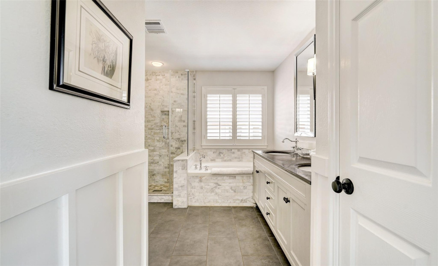 A sneak peek of the primary bathroom; you'll LOVE getting ready in this space; the craftsman wainscotting highlights that no detail was spared!