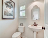 The powder room is located off the first floor, adjacent to the laundry room and discreetly tucked off the kitchen.