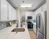 Updated kitchen features quartz countertops, new backsplash, and stainless steel appliances. 
