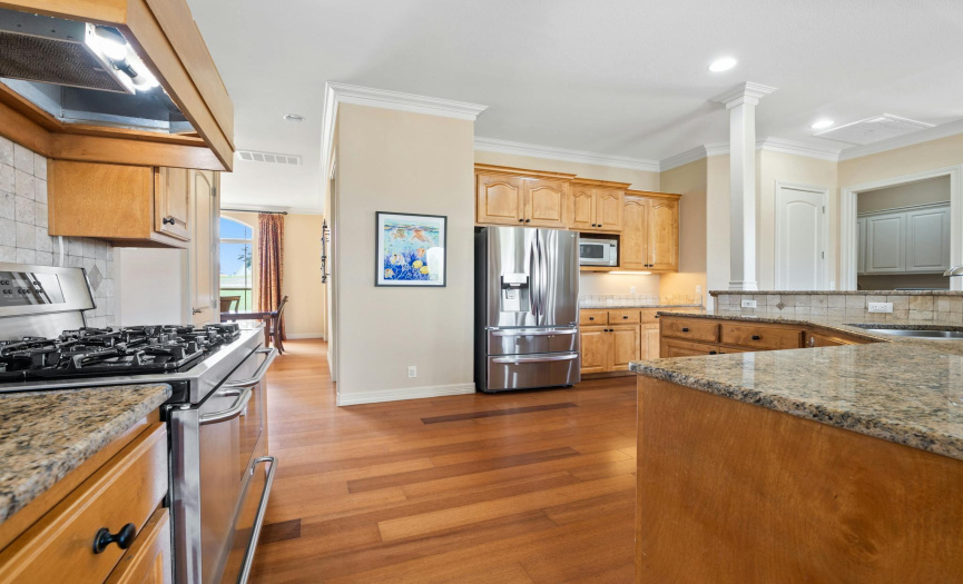 The chef-inspired kitchen is a culinary delight, boasting granite countertops, a stylish tile backsplash, convenient pull-out drawers, stainless steel appliances