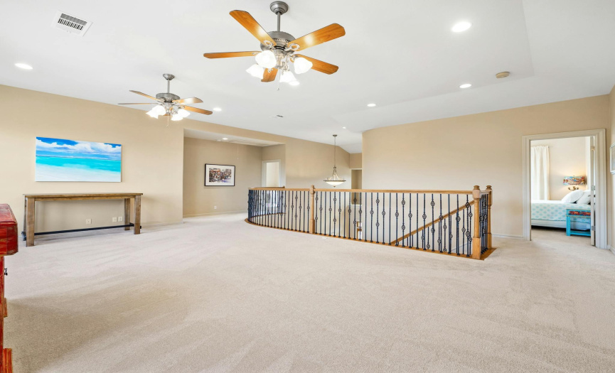 At the top of the stairs you will find the large game room with updated carpet flooring, 2 ceiling fans and neutral toned walls
